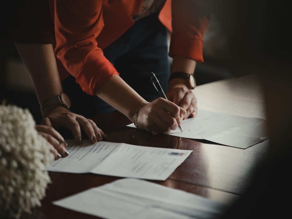 Real estate agreement on a wooden desk with pens, ready for signing.